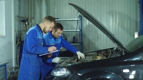 Two mechanics working on a car Stock Footage 70650130