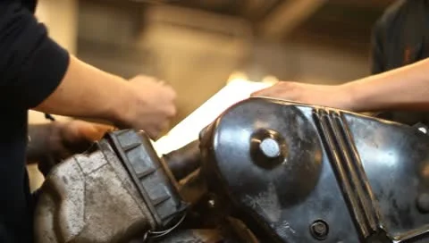 Two mechanics working on engine on engine stand Stock Footage 10588464