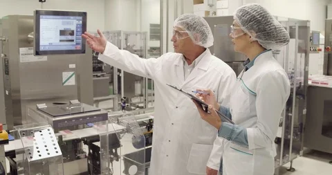 Two medecine factory engineers discussing working process, Stock Footage 101097723