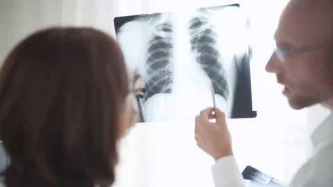 Two medical employees doctors man and woman looking at X ray scan  Stock Footage