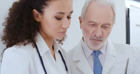 Two medical workers aged man and young woman, doctors talking in hospital Stock Footage 150239755