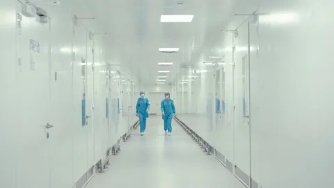 Two medical workers in protective uniform are walking in the hallway of Stock Footage 200855391