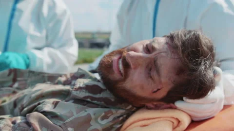 Two medics provide first aid to wounded soldiers screaming in pain in Stock Footage 187689672