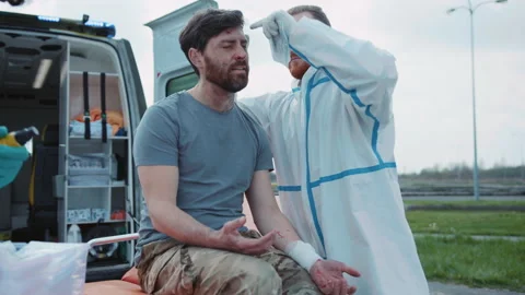 Two medics provide first aid to wounded soldiers screaming in pain near Stock Footage 187694840
