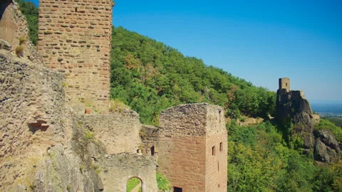 Two medieval castle ruins standing on forested hills above Ribeauville, France Stock Footage 327569110