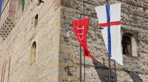 Two medieval flags on the Marostica lower castle with birds flying Stock Footage 66964508