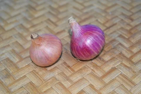 Two medium pieces of fresh red onion placed over a wood colored background Stock Photos