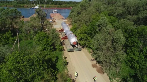 Two men accompany a special platform on which there is a large industrial pipe. Stock Footage 124244653
