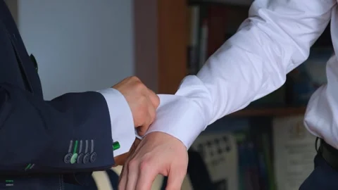 Two men adjusting cufflinks indoors during formal dressing Video stock 342134364