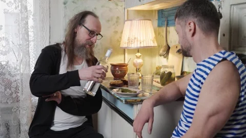 Two men alcoholics drinking vodka sitting on the kitchen 스톡 동영상 333264167