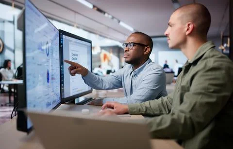 Two Men Analyze Compliance Data Together Using Regulatory Dashboard Tools. Stock Photos