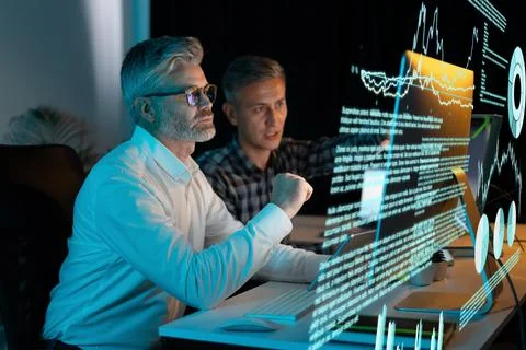 Two Men Analyzing Data on Transparent Screen in Modern Office Stock Photos