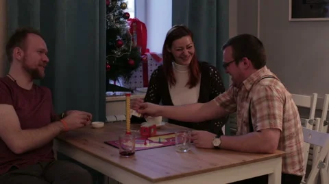 Two men and woman play a board game in a cafe Stock Footage 59168417
