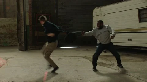 Two men angrily fight over backpack using martial art techniques, in front of an Stock Footage 199458408
