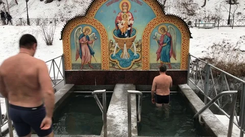 Two men are dipping into cold water in typical way during the Orthodox Epiphany Stock Footage 93028434