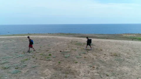 Two men are goes on the ground against the backdrop of the sea landscape Stock-Footage 103089166