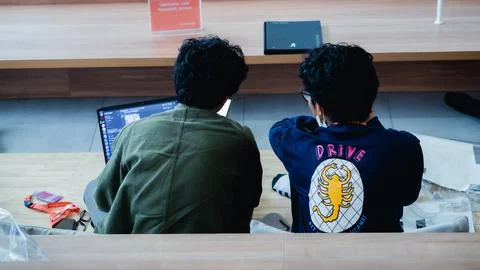 Two men are having a discussion using a cellphone and laptop. Stock Photos