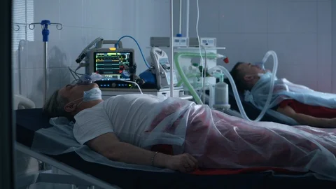 Two men are lying in a hospital and breathing with a ventilator. Coronavirus Stock Footage