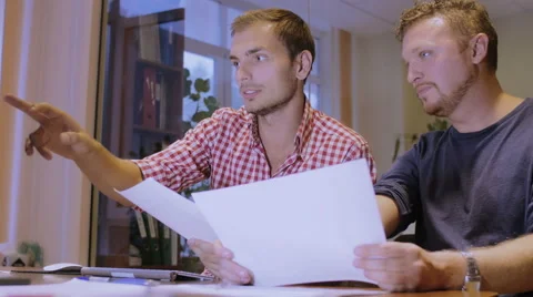 Two men are in office and work over building plan of the house Stock Footage 58016124
