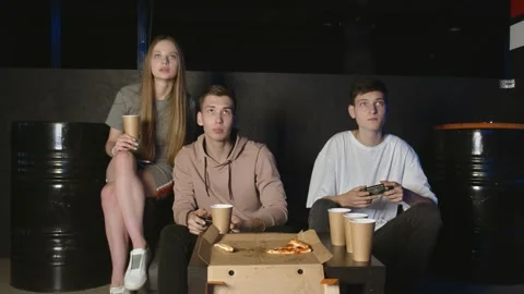 Two men are playing video games and lose. Young friends are sitting on the couch Stock Footage 136338631