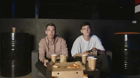 Two men are playing video games and lose. Young guys throws joystick and swears Stock Footage 136339905