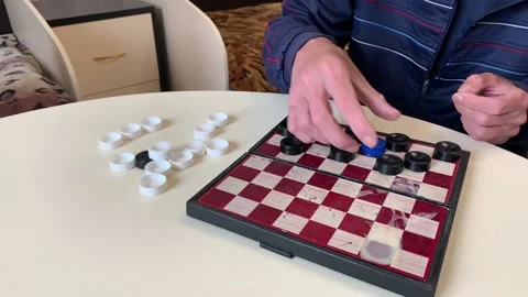 Two men are preparing to play checkers, placing pieces on the board Video stock 157473353