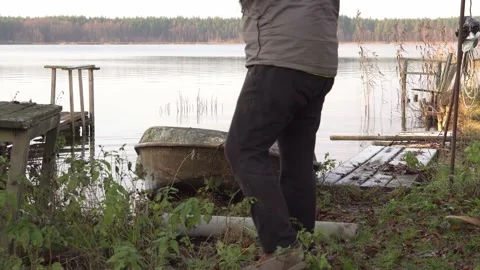 Two men are pulling an old metal boat out of the water on the lake. Stock Footage 143574924