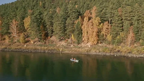 Two men are rafting on a calm river on an inflatable kayak and fishing Stock Footage 285843508