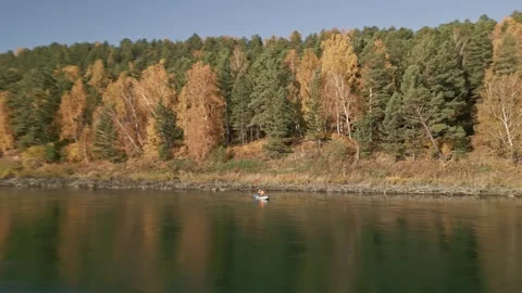 Two men are rafting on a calm river on an inflatable kayak and fishing Stock Footage 285843581