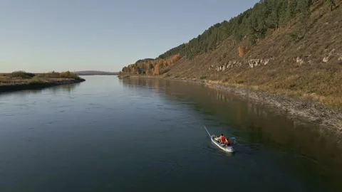 Two men are rafting on a calm river on an inflatable kayak and fishing Stock Footage 285843774