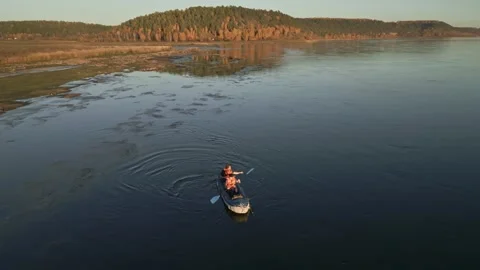 Two men are rafting on a calm river on an inflatable kayak and fishing Stock Footage 285843832