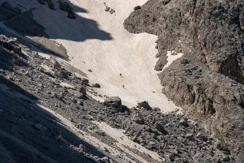 Two men are rappelling down a cliff in the snow. Rocks with snow. Dolomite .. Stock Photos