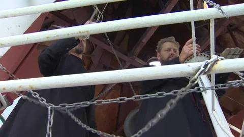 Two men are ringing small bells in the church. Undefined location. Sound. Stock Footage 94921358