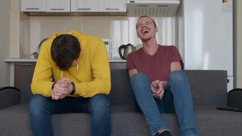 Two men are sitting on the couch and smiling Stock Footage 107647172