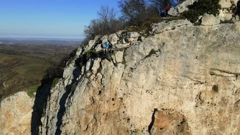 Two men are sitting on the edge of a cliff and talking, Stock Footage 170904318