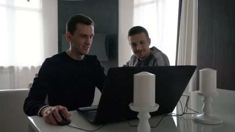 Two men are sitting with a laptop on the table 库存影片 108303756