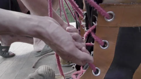 Two men are tying the shoelaces of the diver's large boots. Stock Footage 150765310