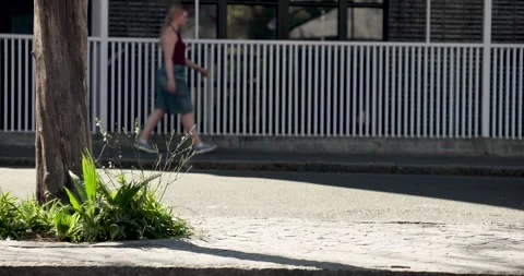 Two men are walking on sidewalk as car is blurring, one pausing, checking Stock Footage 337400298