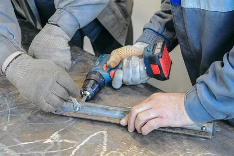Two men are working on a project, one of them is holding a drill Stockfoto's