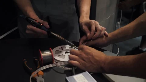 Two men are working with a soldering iron Stock Footage 269510719