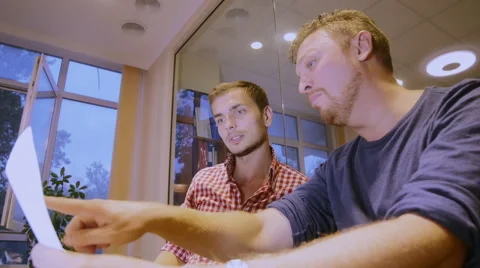 Two men argue and discuss the construction plan of the house Stock Footage 58015363