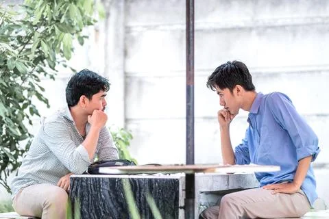 Two men arguing each other in the park. 2 men suspect each other Stock Photos