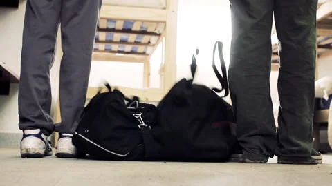 Two Men Arriving at Hostel Dorm With Handbags and Wooden Bunk Beds - Ground View Stock Footage 102145635