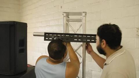 Two Men Assemble Television Mount on Aluminum Truss Stock Footage 343358263