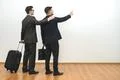 The two men with bags gesture on the white wall background Photo