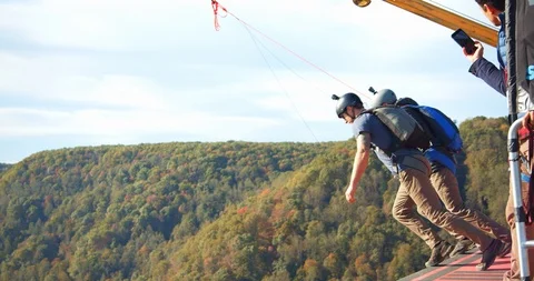 Two Men Base Jumping Off Bridge With Parachute, Slow Motion Backflip Stock Footage 127466731