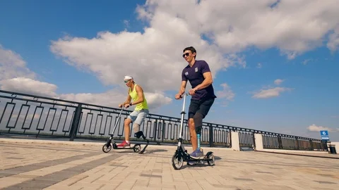 Two men with bionic legs are riding scooters Stock Footage 116800901