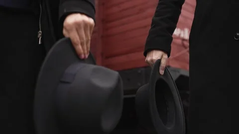 Two men in black clothes take off their hats Stock Footage 314761581