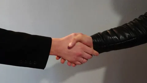 Two men in black shake hands, make a deal, say hello, say goodbye Stock Footage 152083378