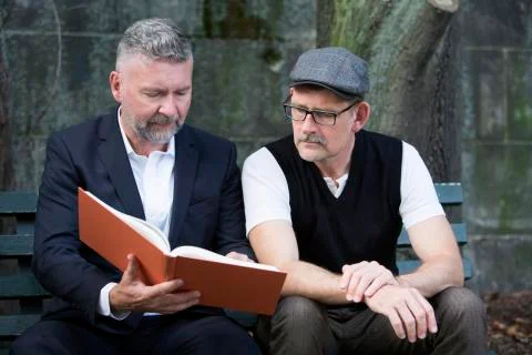 Two men with a book Stock Photos